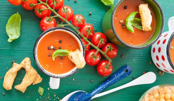 Fresh tomato soup with basil in rustic cup