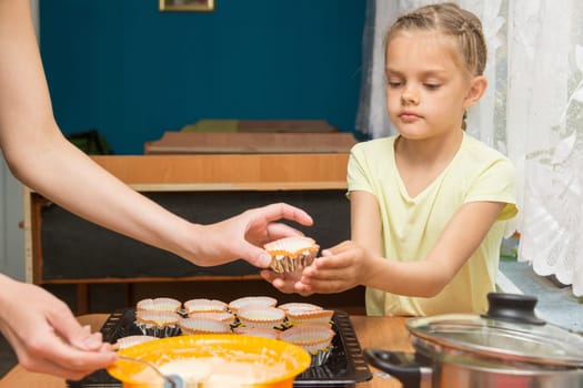 Daughter helps mum to prepare cupcakes for Easter