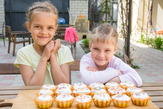 Two girls rejoice freshly baked Easter cupcakes