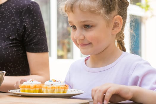Happy girl is preparing to eat Easter cupcakes