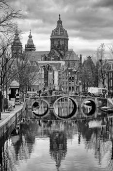 Amsterdam,The Netherlands – December 29,2014: The Basilica of St. Nicholas is reflected with a round arch bridge in a canal on December 29,2014 in Amsterdam.