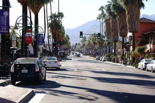 Palm Springs,United States - December 24,2015: Traffic with parked cars on the side strips and a traffic light intersection on canyon drive on December 24,2015 in Palm Springs.