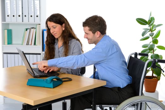 disabled businessman in wheelchair and his female colleague