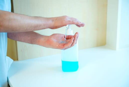hand- disinfecting with blue alcohol in hospital