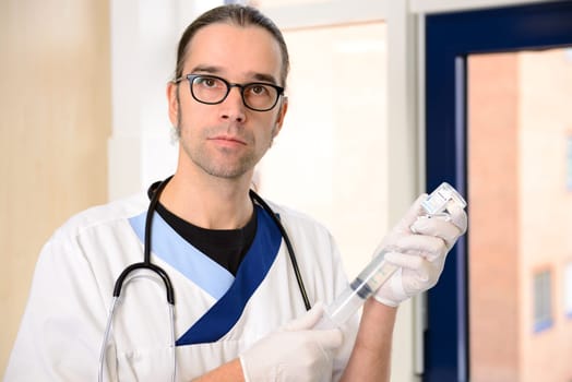 long haired male nurse prepare a liquid medicament