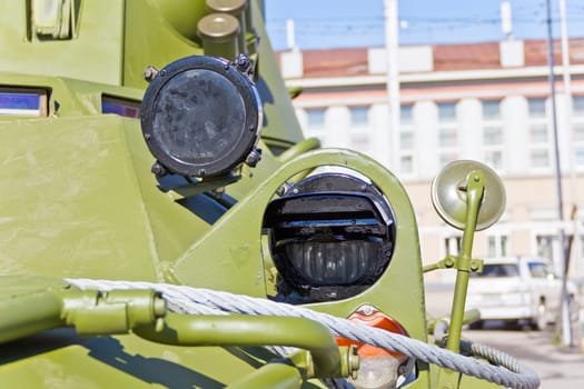 Headlight of military machine at the exhibition under open sky