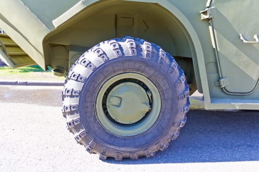 Wheel of military machine at the exhibition under open sky