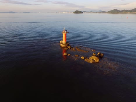 Drone flying over seaside with lighthouse