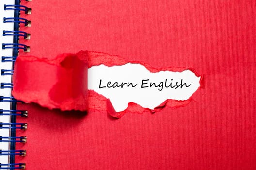 The word learn english appearing behind torn paper