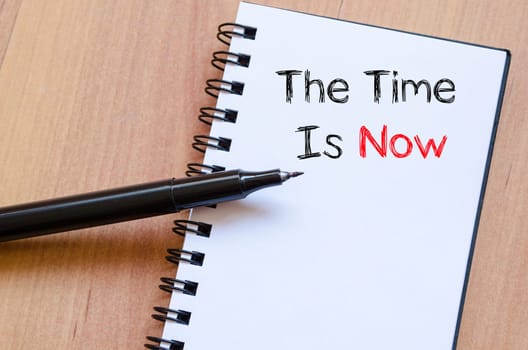 The time is now text concept write on notebook