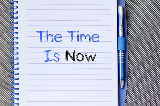 The time is now text concept write on notebook