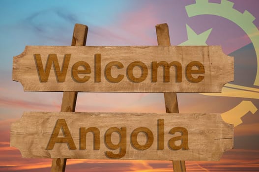welcome to angola sing on wood background with blending national flag