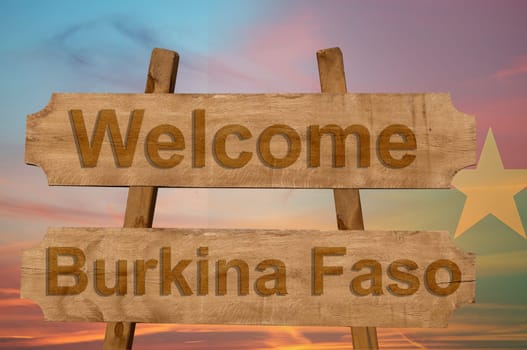 welcome to burkina faso sing on wood background with blending national flag