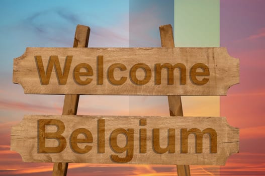 welcome to belgium sing on wood background with blending national flag