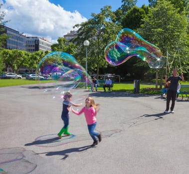 Geneva, Switzerland - June 17, 2016: The children and with soap bubbles attraction at park in the old town of Geneva, Switzerland on 28 July, 2010. It is the second most populous city in Switzerland.