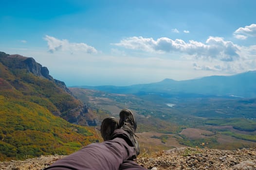 Hiker sitting on the top of the mountain. Mountains in Crimea at the sunny summer day.