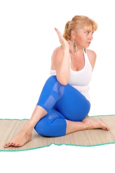 A beautiful blond woman sitting on the floor showing some nice yoga.poses, in a blue pants, isolated for white background..