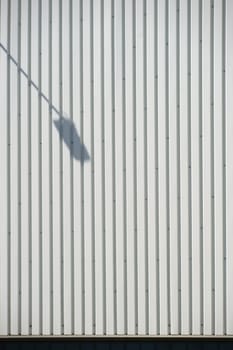 The close-up of a façade made of corrugated iron panels with a lantern shade.