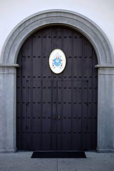 San Juan Capistrano,United States - December 25,2015: The heavy iron-shod front door of the Mission Basilica of San Juan Capistrano with coat of arms on December 25,2015 in San Juan Capistrano.