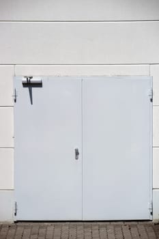 A colorful and striking side wall of a shopping center with an emergency exit and a railing on the first floor.