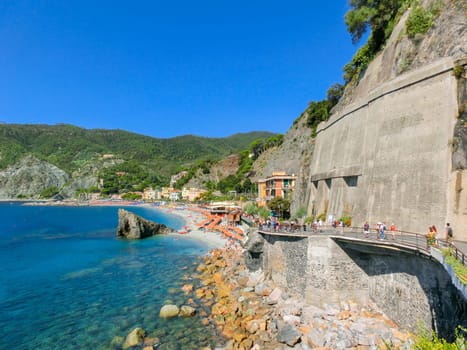 Monterosso, Italy - September 09, 2015: People on the coastline of Monterosso in Italy. Monterosso is one of five famous coastline villages in the Cinque Terre National Park.