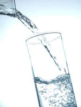 Pouring fresh table water toned in blue, healthy food concept