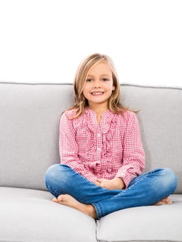 Little girl sitting on a couch and looking to the camera