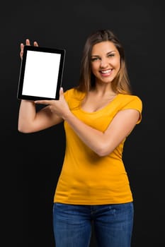 Beautiful woman sitting on the floor working with a tablet