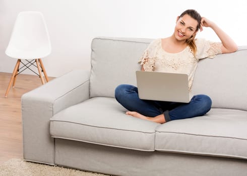 Beautiful woman at home working on her laptop