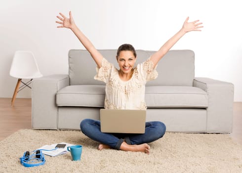 Beautiful happy woman at home working on her laptop