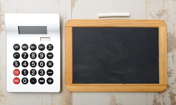 chalkboard and calculator on woolen table