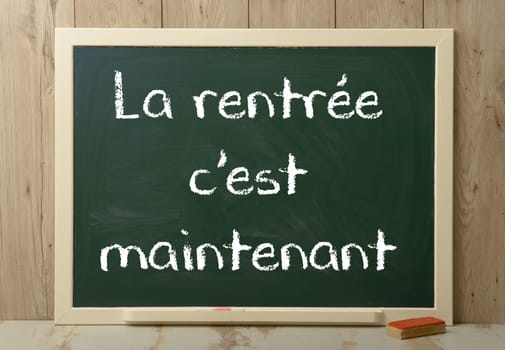 " c est la rentree maintenant"" back to school written on green blackboard"