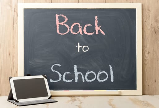 back to school written on blackboard with digital tablet
