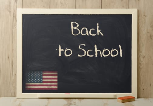 back to school written on blackboard with American flag