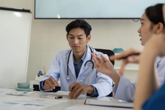A physician leads a meeting with nurses, discussing patient care analysis and healthcare strategies in a professional setting.