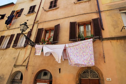 A clothesline with laundry at an old house in Italy. Freshly washed laundry in front of a house
