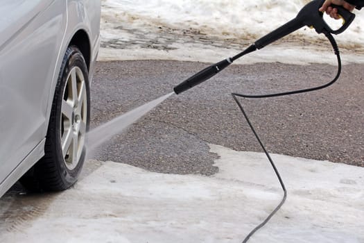 Car wash in winter - A man washes his car