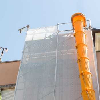 Scaffolding covered with modular slide for debris and rubble
