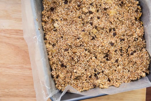 Baking pan full of quinoa and oat bars dough ready for baking