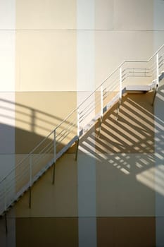 The top edge of a water tank with a walk-in ladder that casts a shadow.