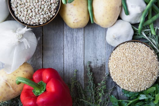 Rustic scene of fresh vegetables, lentils and bulgar wheat with copy space.