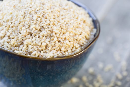 Bowl of dried bulgar wheat in rustic setting.