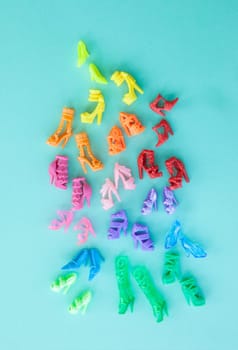 Various colorful women dolls shoes on blue / shopping concept