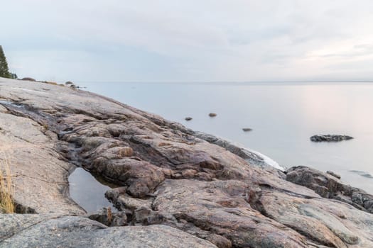 Rocky Shore by Ocean with a cloudy sky.