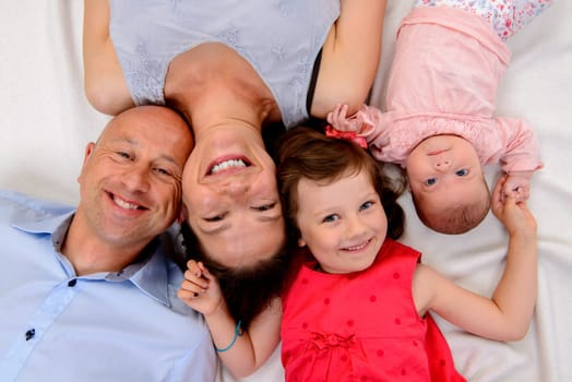 young happy family lying on floor- from top