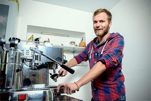 young bearded man in checkered shirt with his espresso machine