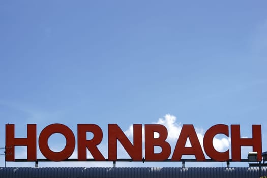 Mainz,Germany – July 08,2016: The orange company sign of the Hornbach DIY store in front of a blue sky with clouds on July 8,2016 in Mainz.