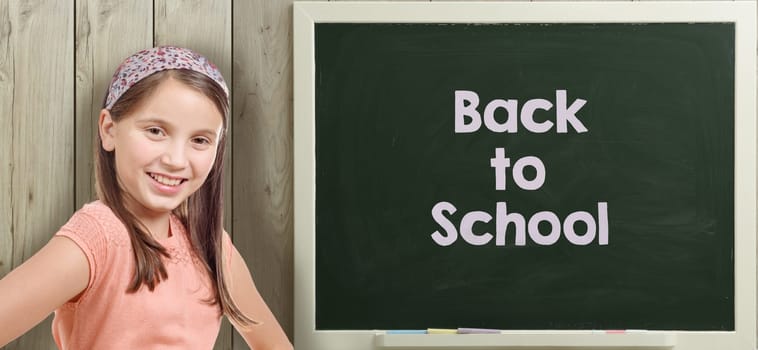 back to school written on  blackboard with pretty young girl