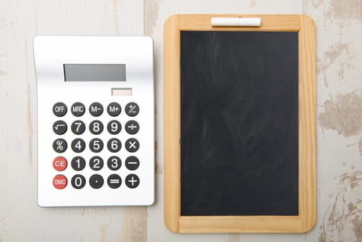 chalkboard and calculator on woolen table