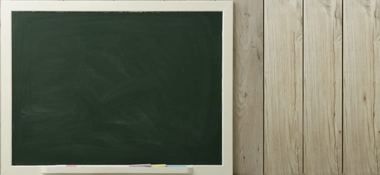 a green blackboard on a wooden background